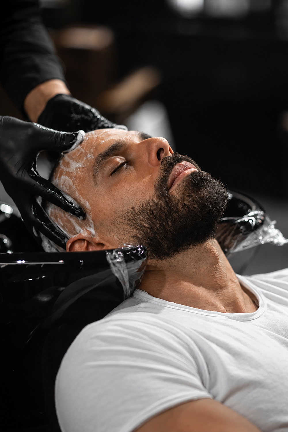 Shampoing au bac, tête renversée, mousse et mains gantées